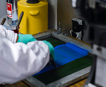 Employee performing a test application of a screen-printed coating by hand